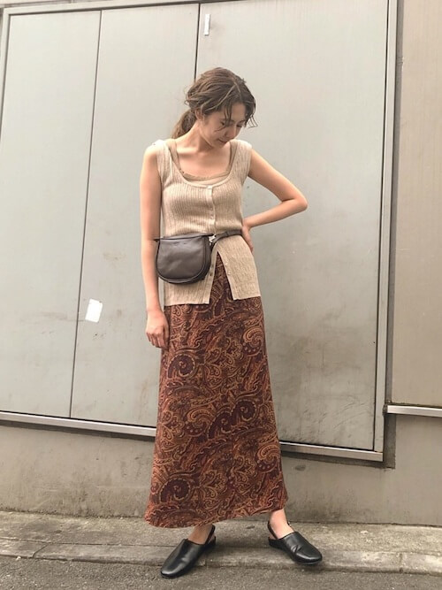 黒のスリッポン×ベージュのタンクトップ×ブラウンの柄スカート×黒のバッグ