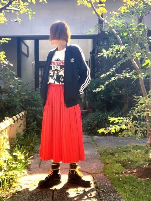 赤のプリーツスカート×黒のトラックジャケット×白のロゴTシャツ×黒のブーツ