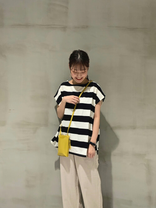 バイソン柄のウォレットバッグ×ピンクのベスト×ベージュのタンクトップ×白のパンツ