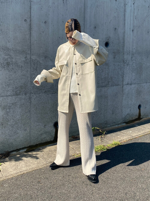ベージュのレザージャケット×白のトレーナー×ベージュのフレアパンツ×黒のサンダル