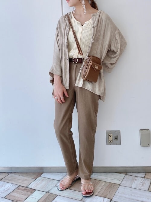 ブラウンのウォレットバッグ×ベージュのシャツ×ベージュのタンクトップ×ブラウンのパンツ
