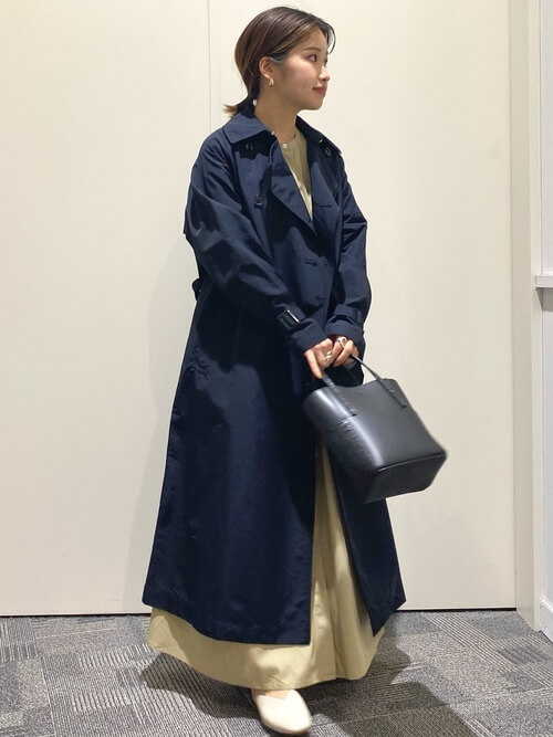 ネイビーのトレンチコート×ベージュのワンピース×ベージュのパンプス×黒のバッグ