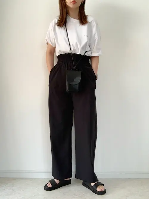 白のロゴTシャツ×黒のワイドパンツ×黒のサンダル
