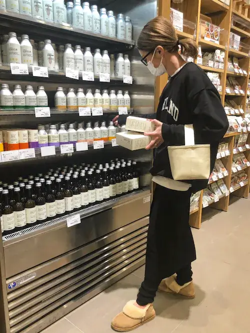 キャメルのムートンブーツ×黒のスエット×黒のスカート×ベージュのバッグ