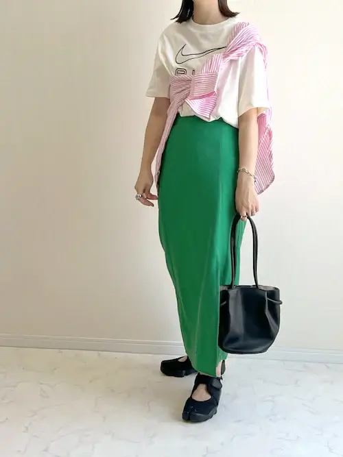 ピンクシャツ×白のロゴT×グリーンのタイトスカート×黒のスニーカーサンダル