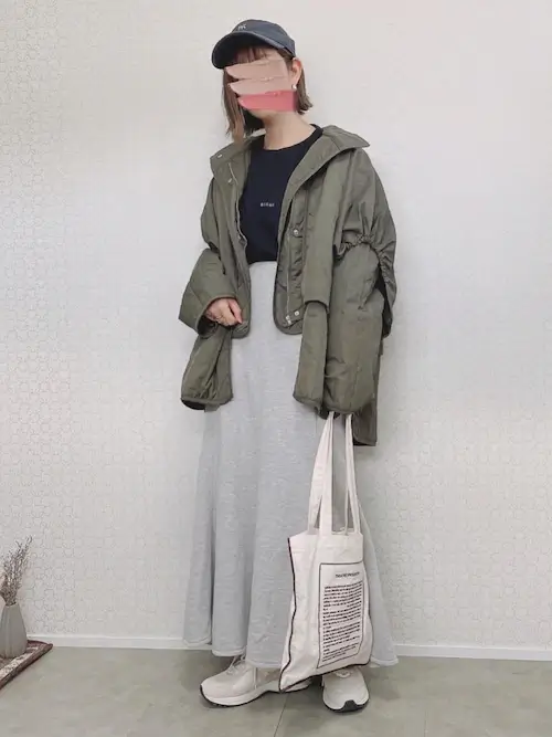緑のジャケット×黒のロゴT×グレーのスカート×白スニーカー