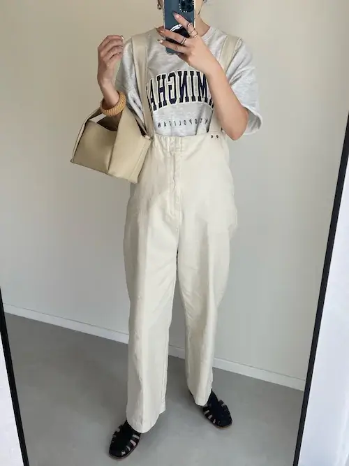 スウェットTシャツ×白のサロペット×黒のグルカサンダル×ベージュのバッグ
