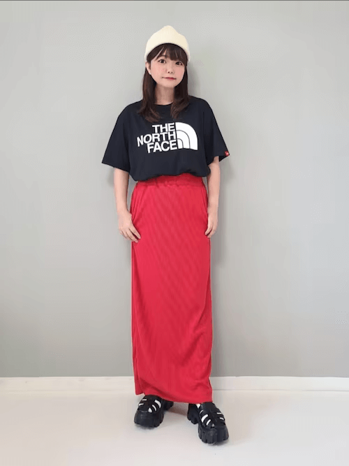 Tシャツ/カットソーのタックイン：黒のロゴT×赤のタイトスカート×黒のグルカサンダル