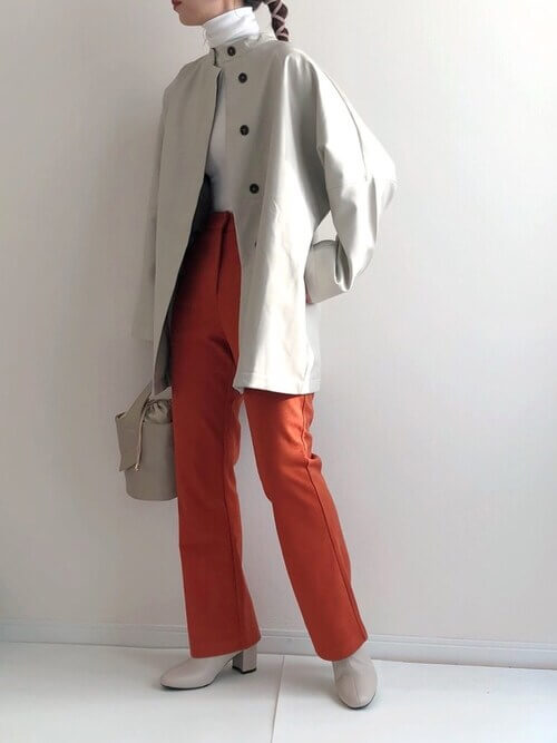 白のレザージャケット×白のハイネックトップス×オレンジパンツ×ベージュのブーツ